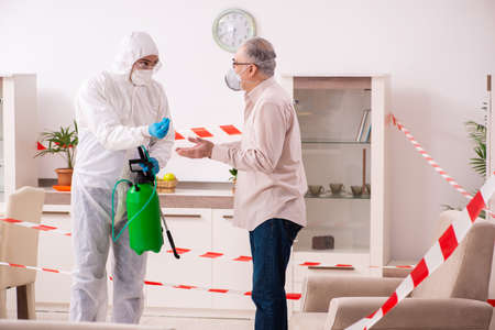 Young male sanitizer and old man indoors