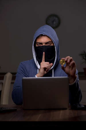 Male hacker hacking security firewall late in officeの写真素材