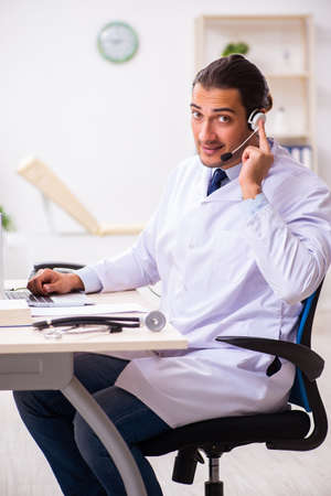 Young doctor listening to patient during telemedicine sessionの写真素材