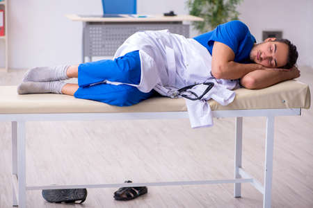 Young male doctor being tired after night shift