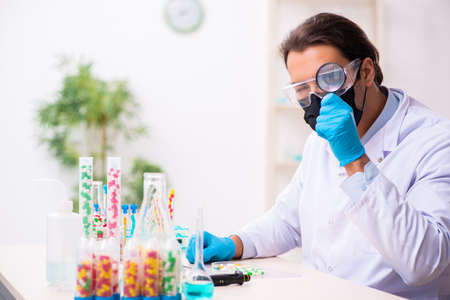Young male chemist in drug synthesis concept