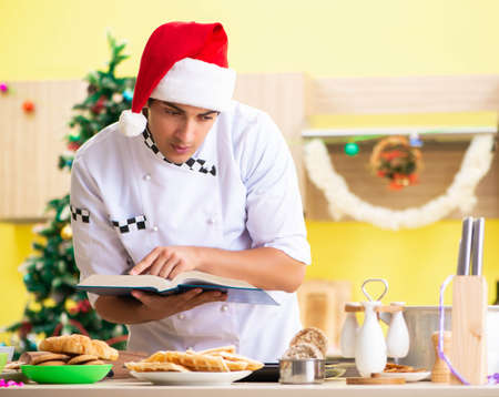 Young chef husband working in kitchen at Christmas eveの写真素材