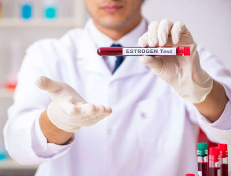 The young handsome lab assistant testing blood samples in hospitalの写真素材
