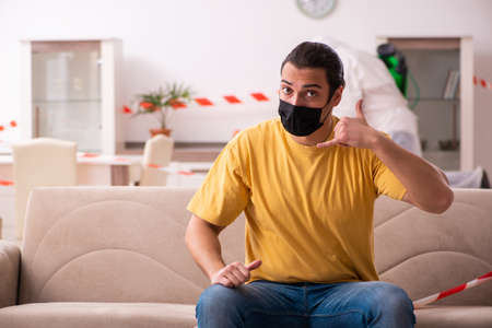 Sanitizer and young man indoors in disinfection conceptの写真素材