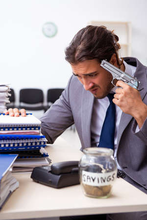 Young male employee unhappy with excessive workの写真素材