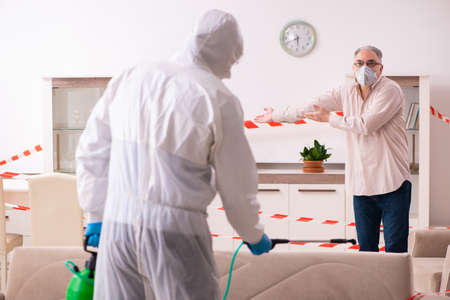 Young male sanitizer and old man indoorsの写真素材