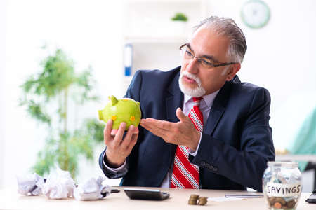 Old male accountant in budget planning conceptの写真素材
