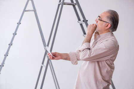 Old husband contractor in renovation conceptの写真素材