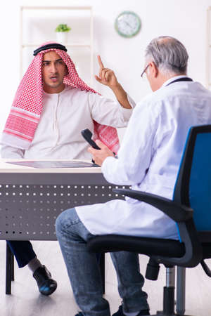 Young male arab visiting experienced male doctorの写真素材