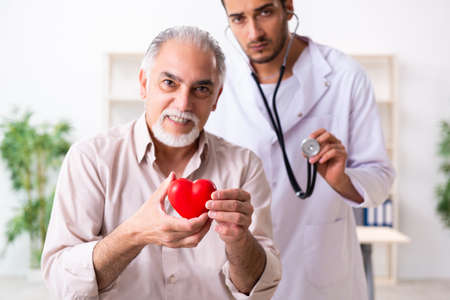 Old man visiting young male doctor cardiologist