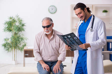 Old blind man visiting young male doctor