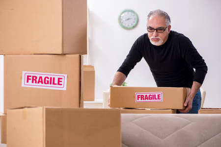 Old male professional mover doing home relocationの写真素材