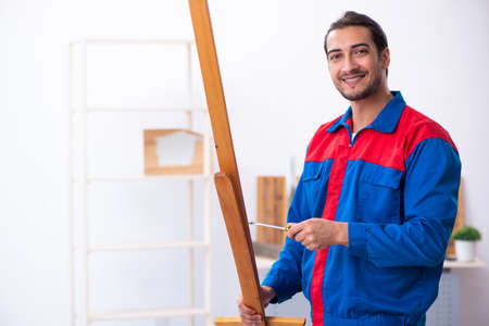 Young male contractor working in workshop