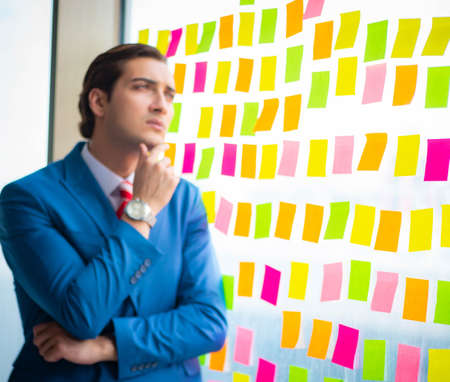 Young handsome employee with many conflicting priorities
