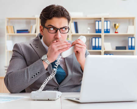 Businessman leaking confidential information over phoneの写真素材