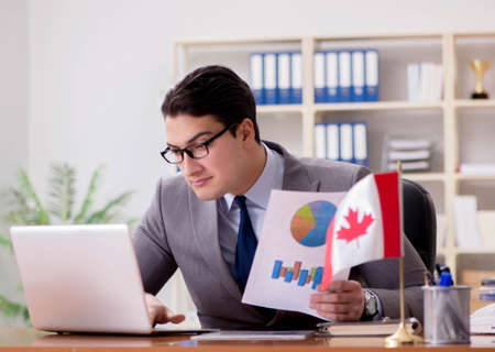 Businessman with Canadian flag in officeの写真素材