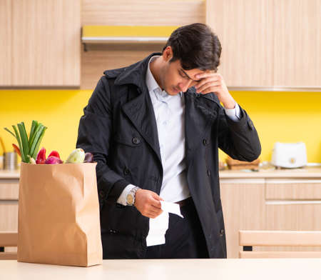 Young handsome man with vegetables in kitchenの写真素材