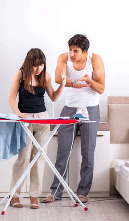 Young woman doing ironing for her husbandの写真素材