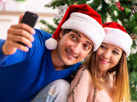 Pregnant wife celevrating christmas with husbandの写真素材