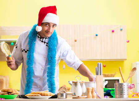 Young chef husband working in kitchen at Christmas eveの写真素材