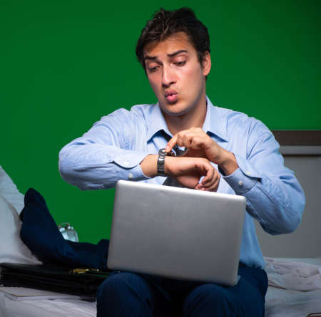 Young businessman under stress in the bedroom at nightの写真素材