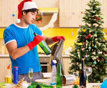 Young man cleaning kitchen after Christmas party