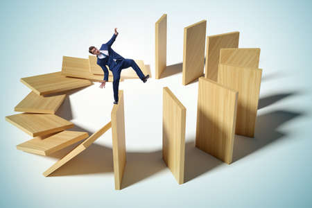 Businessman in the domino effect concept