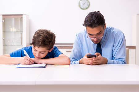 Busy father helping his son to prepare for exam