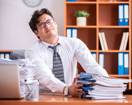 Young handsome businessman unhappy with excessive workの写真素材