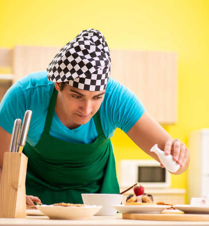 The man cook preparing cake in kitchen at homeの写真素材