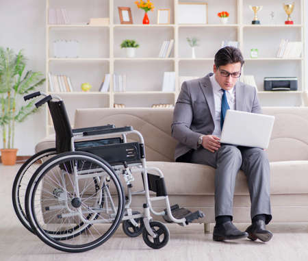 Dsabled businessman on wheelchair working homeの写真素材