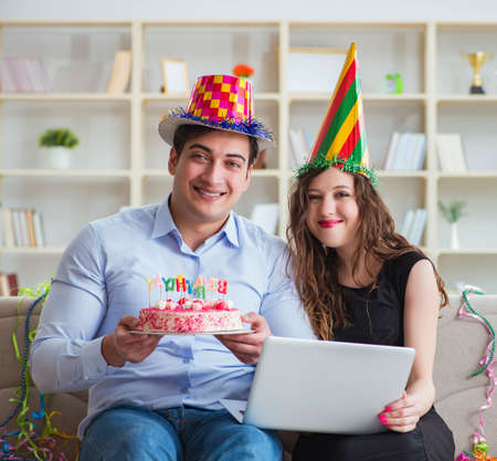 Young couple celebrating birthday with cakeの写真素材