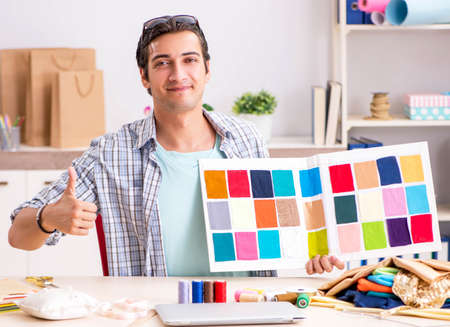 Young handsome tailor working in his workshopの写真素材