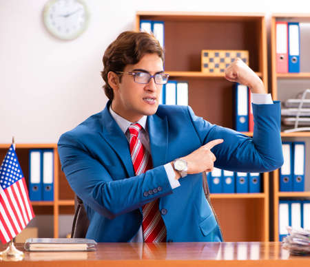 Young handsome politician sitting in officeの写真素材