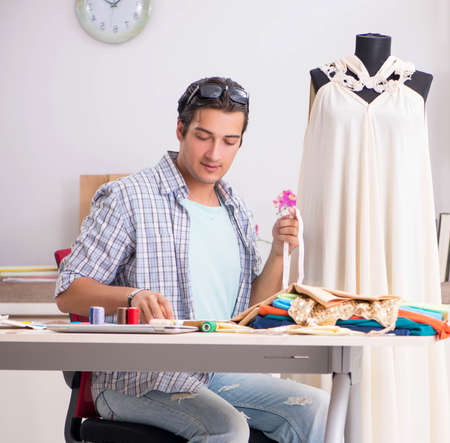 Young handsome tailor working in his workshopの写真素材