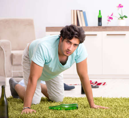 Young drunk handsome man after party at homeの写真素材