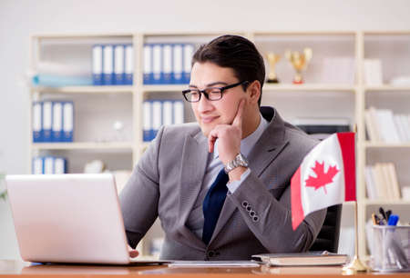 Businessman with Canadian flag in officeの写真素材
