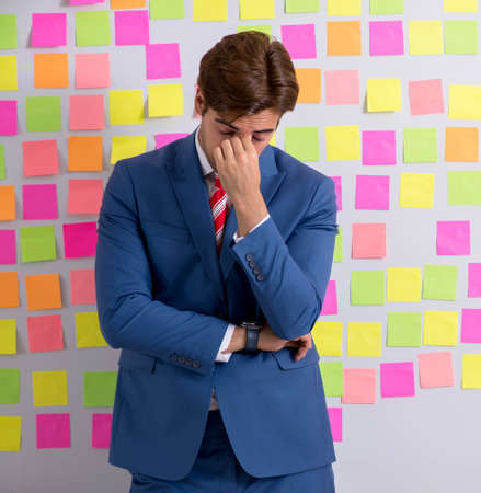 Young handsome man in conflicting priorities conceptの写真素材