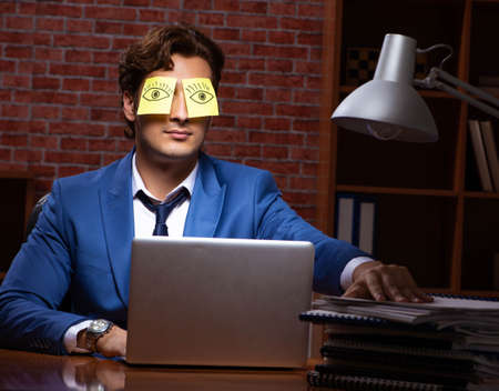 Young businessman working in the office at nightの写真素材