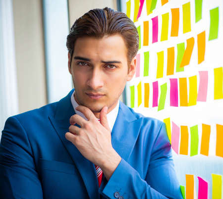 Young handsome employee with many conflicting prioritiesの写真素材