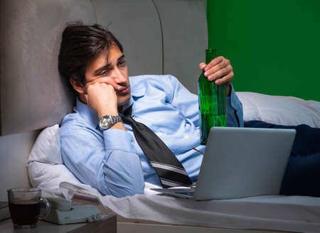 Young businessman under stress in the bedroom at nightの写真素材