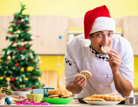 Young chef husband working in kitchen at Christmas eveの写真素材