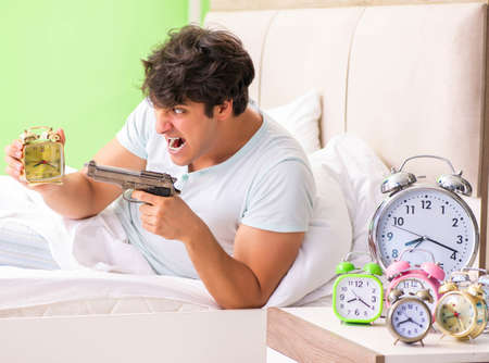 Young man having trouble waking up in early morningの写真素材