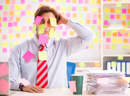 Young handsome man in conflicting priorities conceptの写真素材