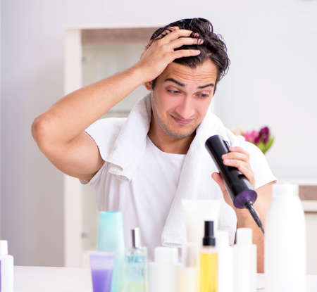 Young handsome man in the bathroom in hygiene conceptの写真素材
