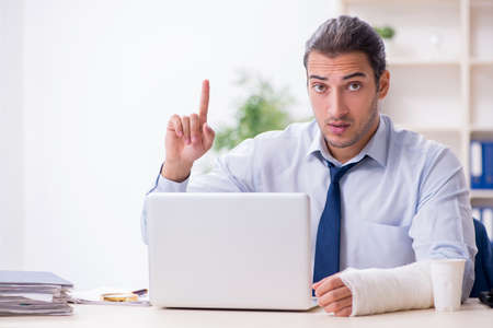 Injured male employee at workplace after accidentの写真素材