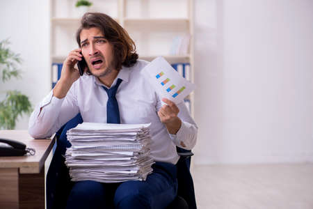 Young male employee unhappy with excessive work