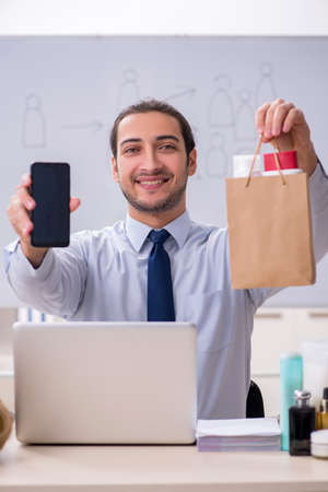 Young male shopaholic in e-commerce conceptの写真素材