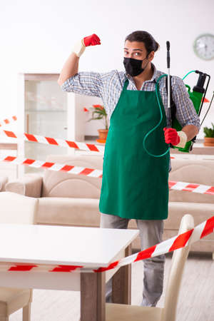 Young male sanitizer disinfecting indoorsの写真素材