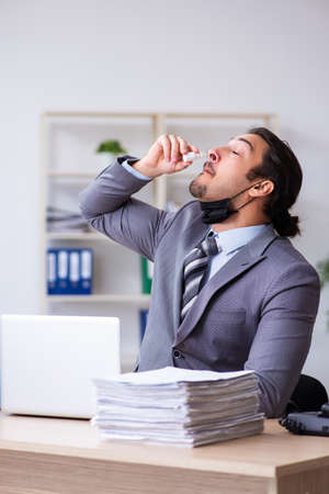 Young male employee in self-quarantine conceptの写真素材